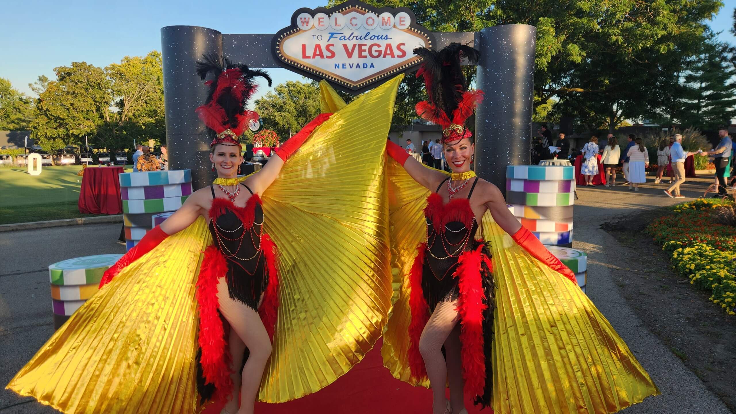 Showgirls in front of the Welcome to Las Vegas sign at the Grand Geneva resort during a casino party