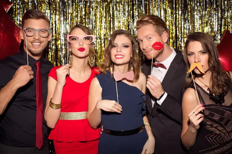 Group posing for a photo in front of a gold backdrop