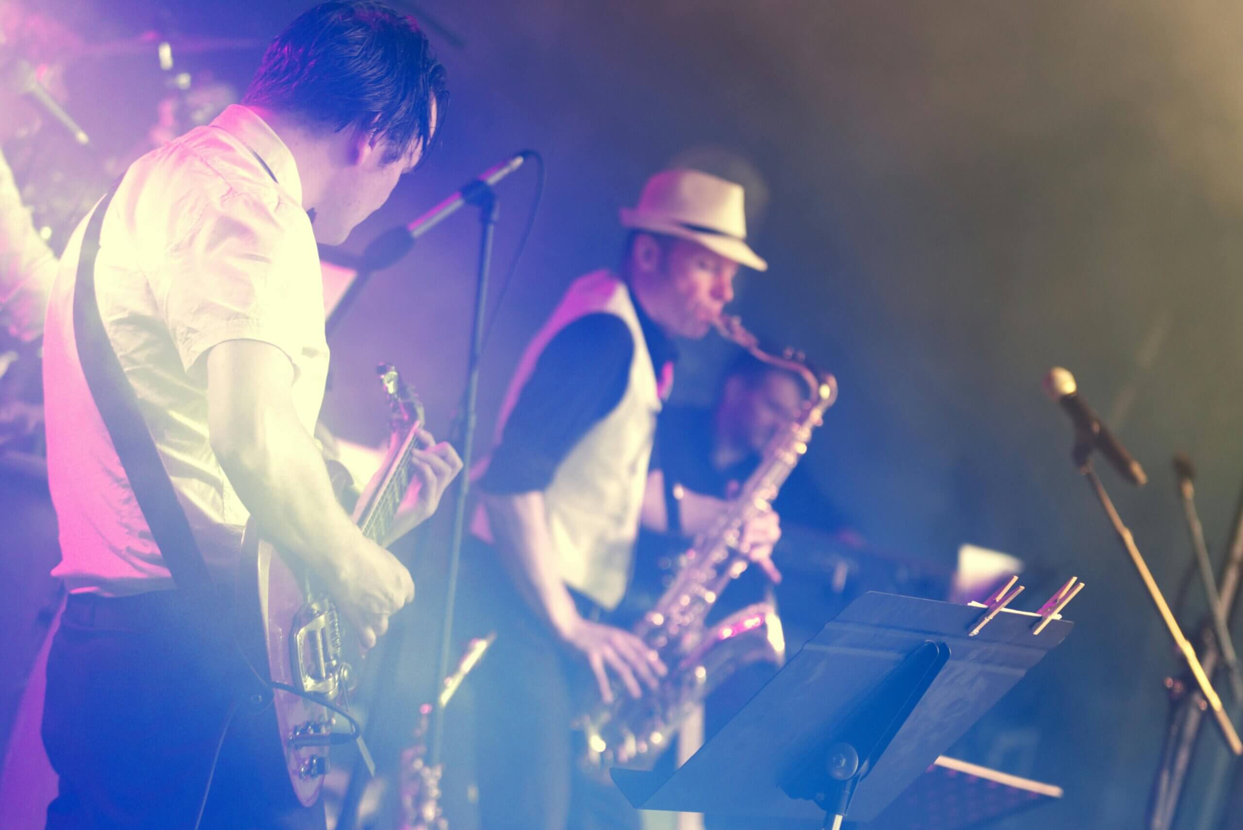 Live musician playing the saxophone and guitar 