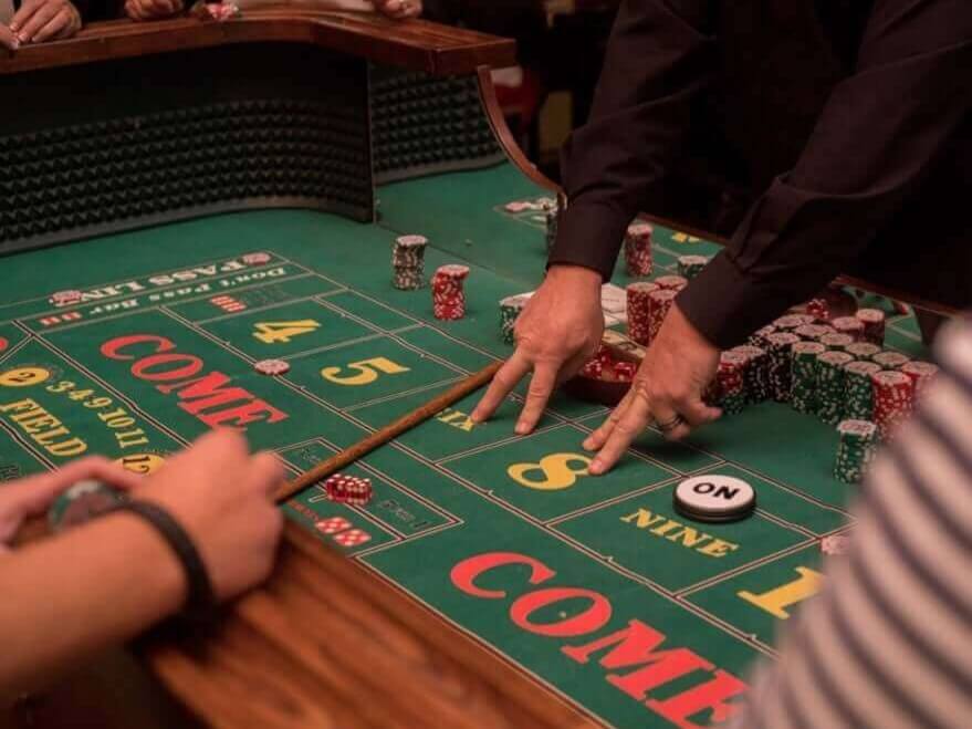 Craps table with dealer teaching players at a corporate casino party